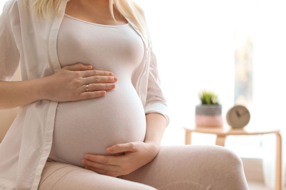 Sperm donasyonu tedavisiyle hamile kalan bir kadın karnını tutuyor